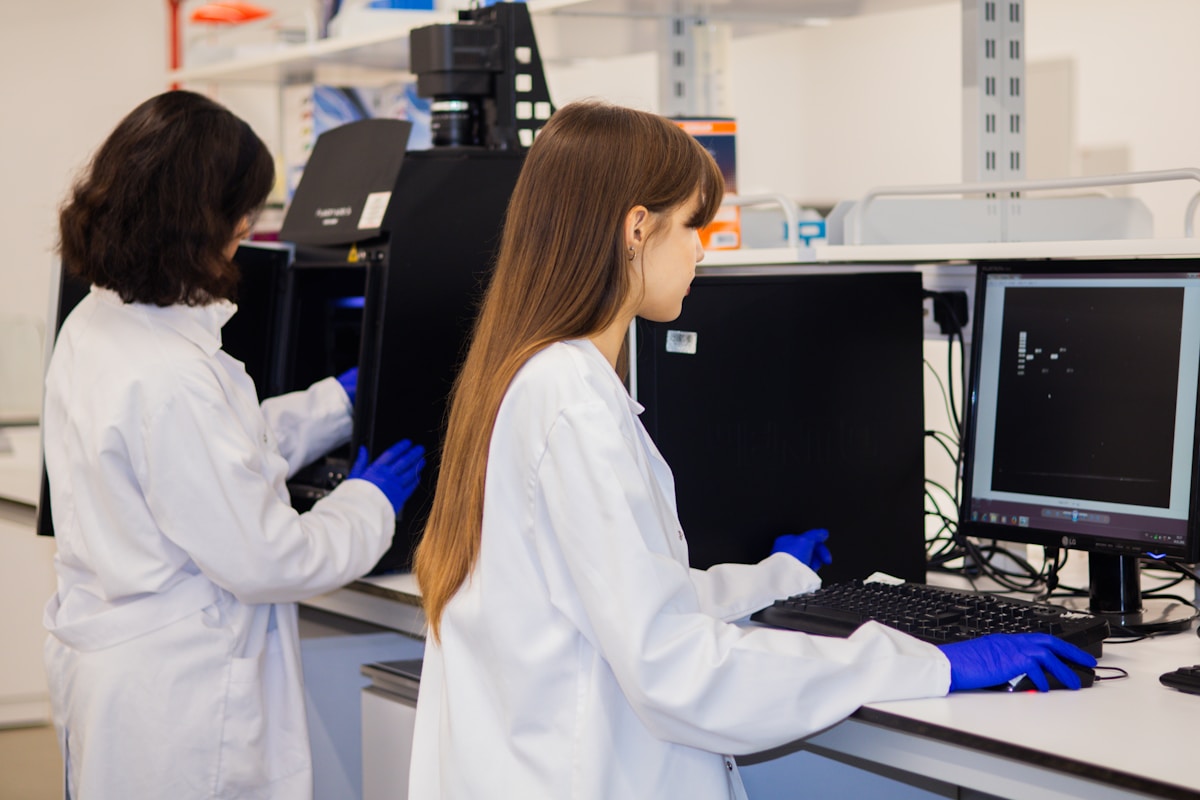 Two researchers using specialist laboratory equipment and computer analysis systems