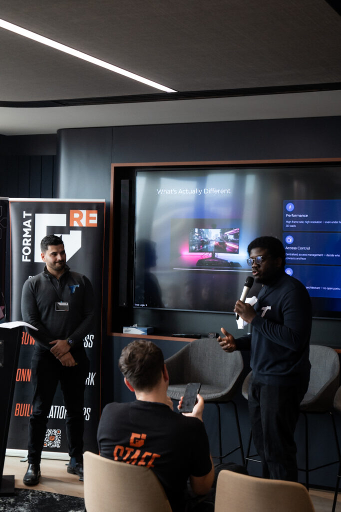 Oluwagbenga Obasa presenting LoLa streaming technology with FORMAT branding and summit attendees visible at RE:FORMAT Manchester 2026.